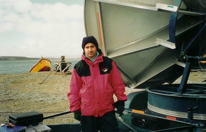 Photo of the author beside a large satellite dish In Porvenir, Chile, packing up to travel / drive 272 miles (438km) overnight to Ushuaia. Freezing cold - down to minus ten and blowing a gale.