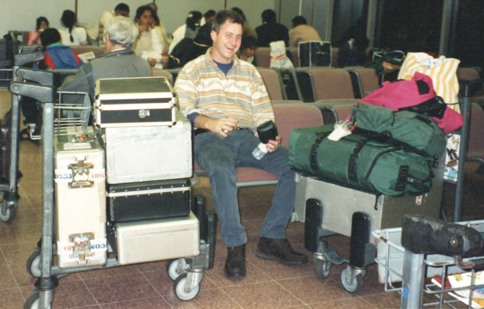 Photo of the author with 211Lbs (96kgs) of equipment on two trolleys at Heathrow airport