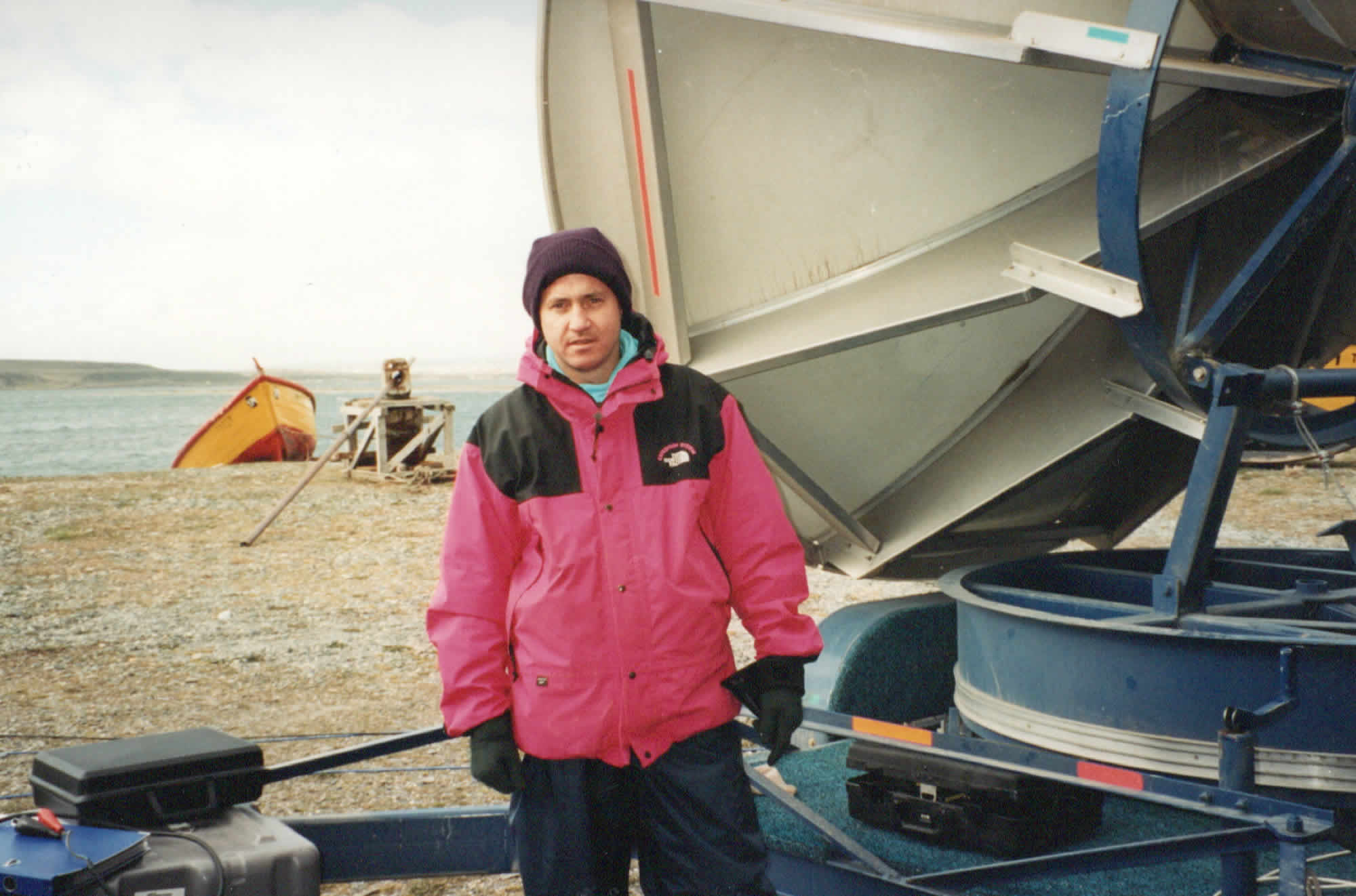 Photo of the author standing by the satellite dish at the end of the first transmission